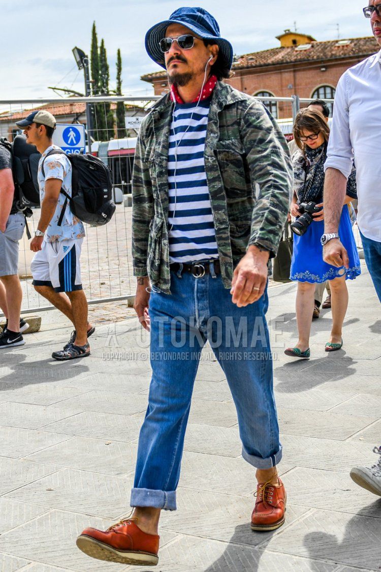 Men's spring/summer/fall outfit with solid blue hat, solid sunglasses, red dot bandana/neckerchief, multi-colored olive green camouflage M-65, blue/white striped t-shirt, solid black tape belt, solid blue denim/jeans, brown work boots Outfit.