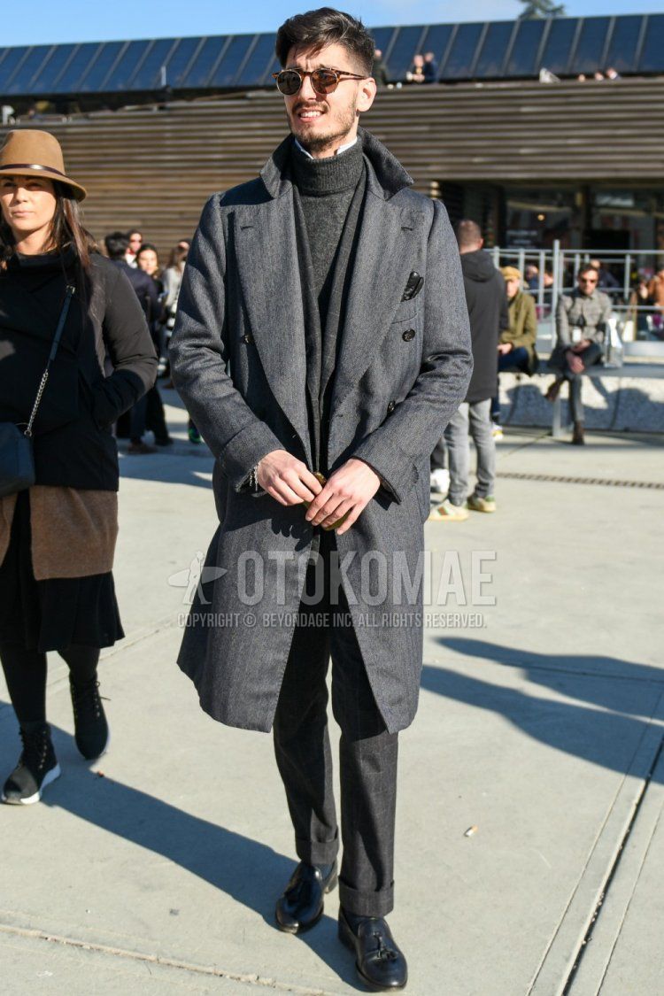 Men's fall/winter outfit with brown tortoiseshell sunglasses, gray checked scarf/stall, solid gray chester coat, solid gray turtleneck knit, gray checked slacks, solid black socks, black tassel loafer leather shoes.