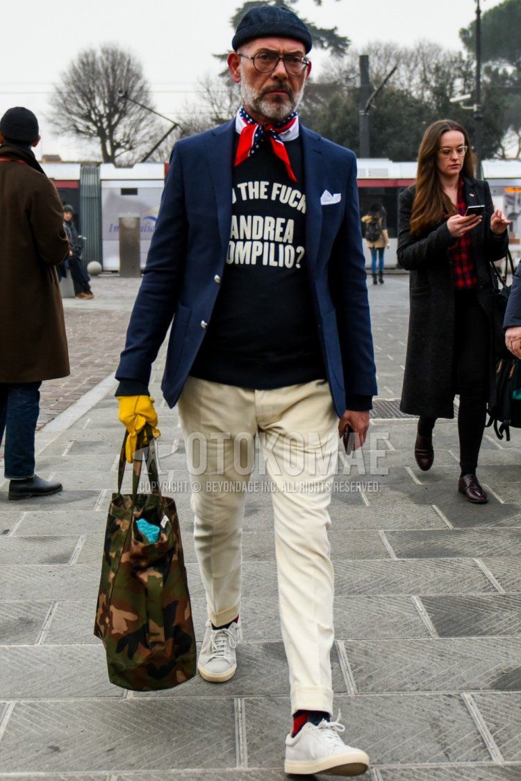 Solid navy cap, solid glasses, multi-colored solid bandana/neckerchief, solid navy tailored jacket, black graphic trainers, solid white cotton pants, solid red socks, white low cut sneakers, green camouflage tote bag, winter Men's Codes and Outfits.