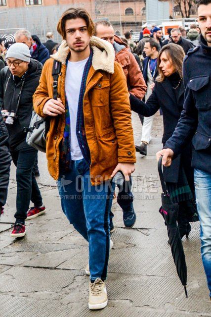 Men's fall/winter coordinate and outfit with solid beige hooded coat, multi-colored top/inner tailored jacket, solid white t-shirt, solid blue denim/jeans, solid sideline pants, and Nike beige low-cut sneakers.