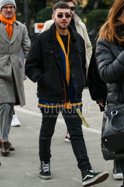 Gold solid black sunglasses, solid black denim jacket, solid yellow-blue cardigan, solid black long tee, off-white yellow graphic tape belt, solid black skinny pants, solid black damaged jeans, Vans Skate High black high-cut sneakers Men's fall/winter coordinate and outfit.