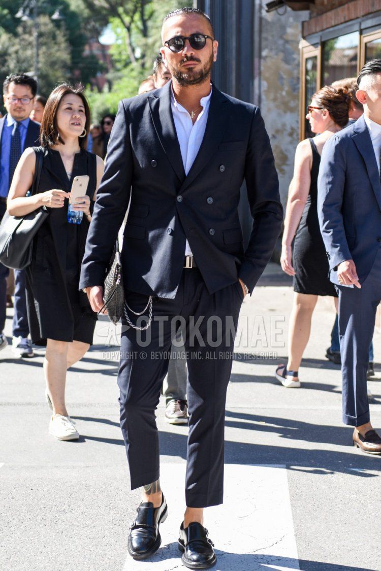Men's spring/autumn outfit and outfit with plain black sunglasses in Boston, plain white shirt with band collar, plain black leather belt, black monk shoes leather shoes, plain black clutch bag/second bag/drawstring, and plain black suit.
