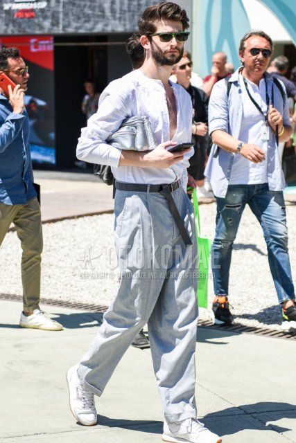 Men's spring/summer coordinate and outfit with plain green sunglasses, plain white shirt with no collar, plain gray tape belt, plain gray slacks, and white low-cut Reebok sneakers.