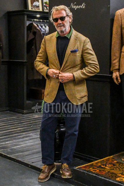 Men's spring and autumn coordinate and outfit with plain sunglasses, beige checked tailored jacket, plain black sweater, plain olive green shirt, plain navy chinos, and brown leather shoes.