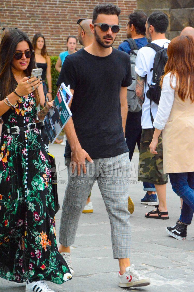 Men's spring and summer coordinate and outfit with plain gray sunglasses, plain black t-shirt, gray checked slacks, gray checked cropped pants, and white low-cut Converse Chevron & Star sneakers.