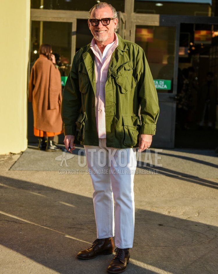 Men's fall/winter outfit with brown tortoiseshell sunglasses, olive green solid color safari jacket, pink solid color shirt jacket, band collar solid color white shirt, solid color white cotton pants, solid color white cropped pants, brown work boots.