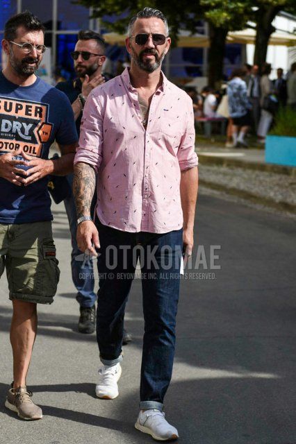Men's spring/summer/fall coordinate and outfit with plain sunglasses, pink top/inner shirt, plain blue denim/jeans, and New Balance white low-cut sneakers.