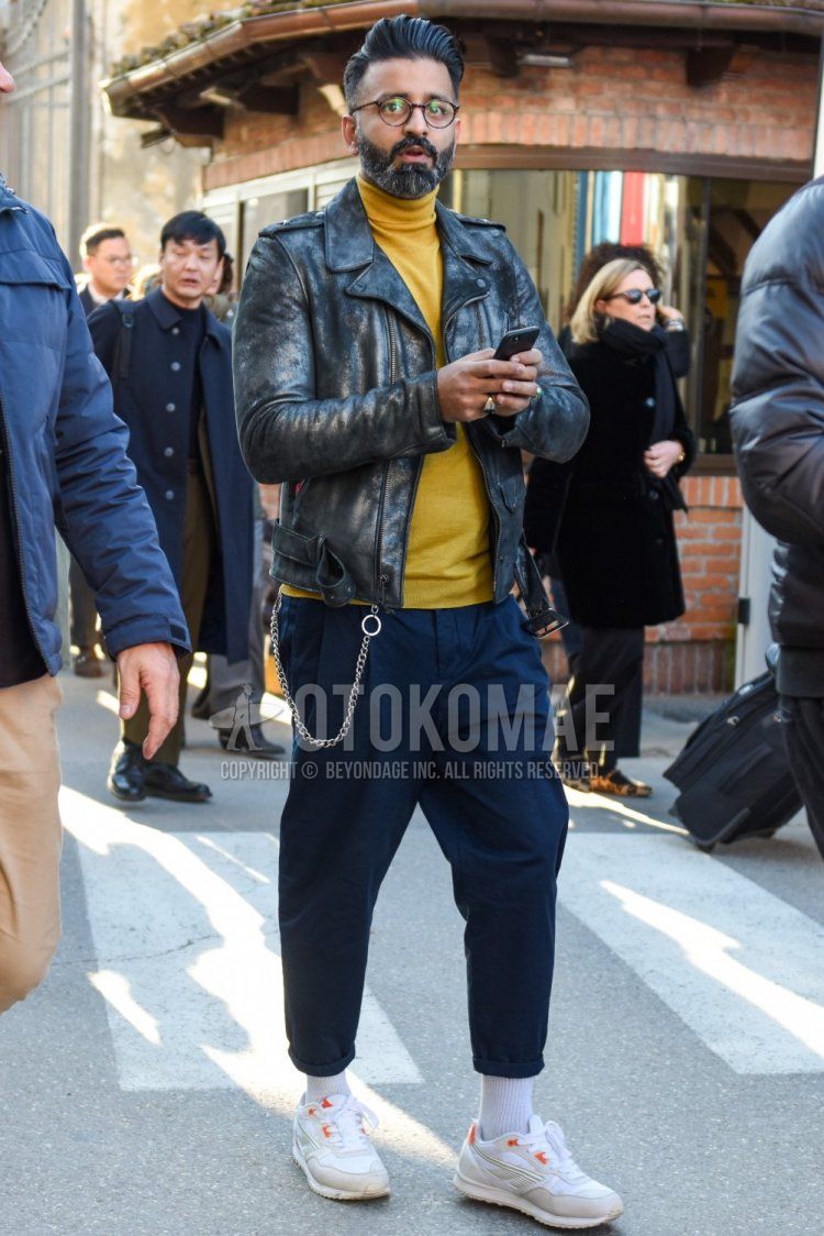 Men's fall/spring coordinate and outfit with brown tortoiseshell glasses, plain black rider's jacket, plain yellow turtleneck knit, plain navy chinos, plain navy pleated pants, plain white socks, and white low-cut sneakers.