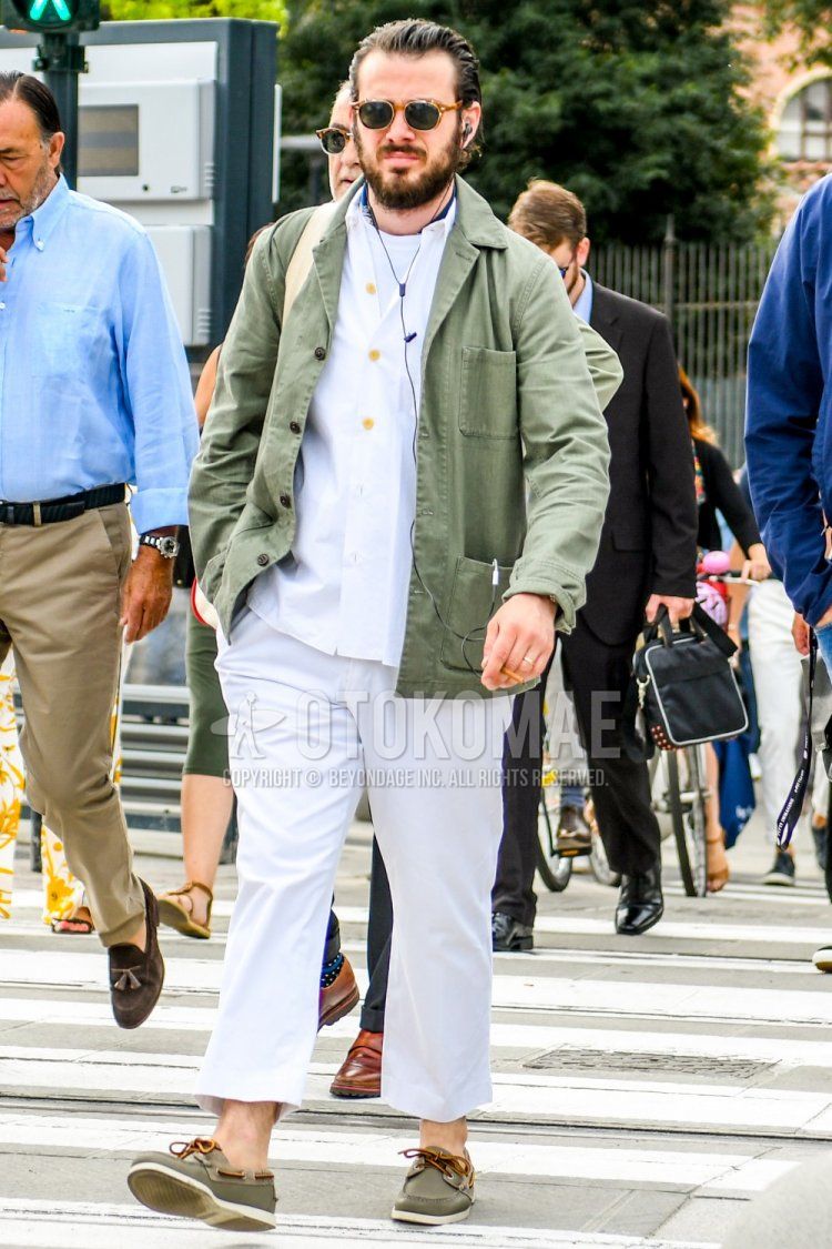 Men's spring/autumn coordinate and outfit with brown tortoiseshell sunglasses, plain green coveralls, plain white shirt, plain white t-shirt, plain white cotton pants, plain white cropped pants, and beige moccasins/deck shoes leather shoes.