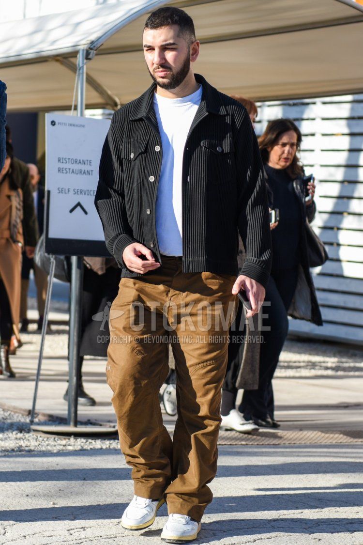 Men's spring and fall coordinate and outfit with plain black denim jacket, plain white T-shirt, plain beige chinos, and white low-cut sneakers.
