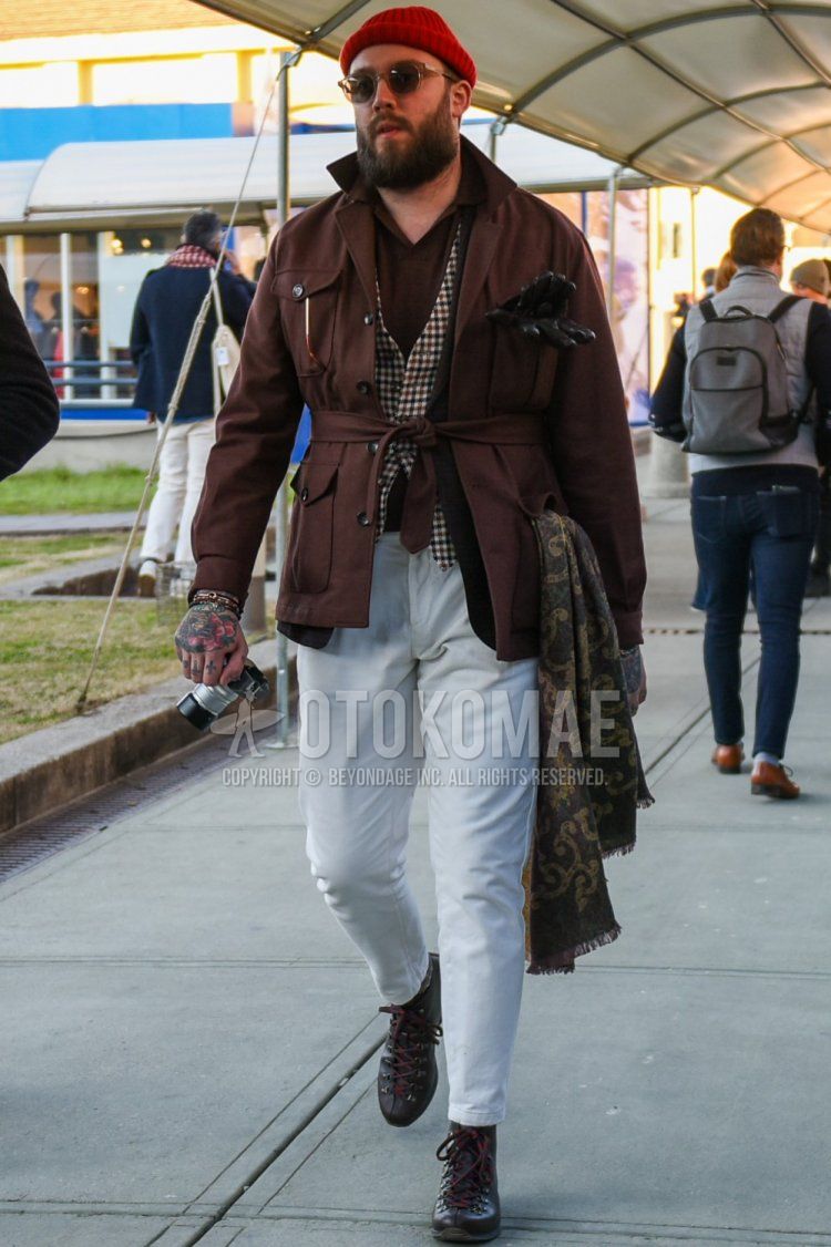 Spring and fall men's coordinate and outfit with red solid knit cap, clear solid sunglasses, brown solid safari jacket, brown solid polo shirt, brown checked gilet, white solid cotton pants, white solid cropped pants, and brown boots.