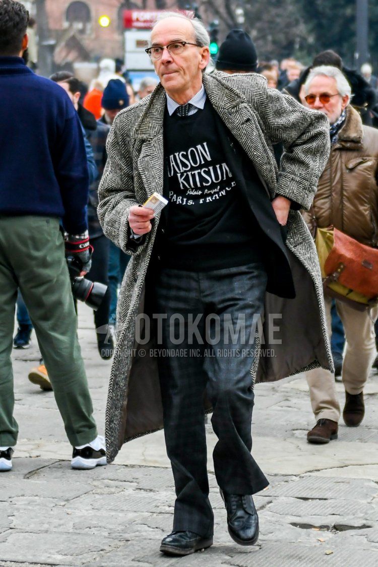Plain black glasses, gray herringbone Ulster coat, black Maison Kitsune trainers with big black logo, white striped shirt, plain black tailored jacket, gray checked slacks, gray checked wide pants, black wingtip leather shoes, and black dot tie for fall and winter Men's Codes and Outfits.