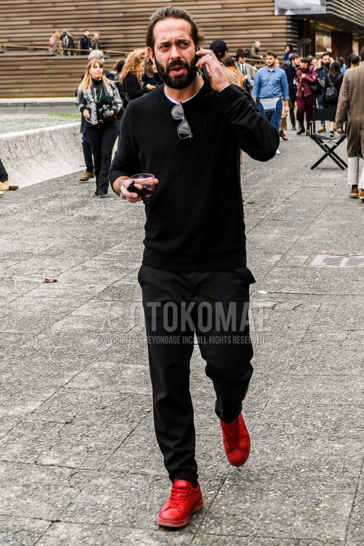 黒無地のセーター、白無地のTシャツ、グレー無地のスラックス、レッドローカットのスニーカーを合わせた春秋のメンズコーデ・着こなし。