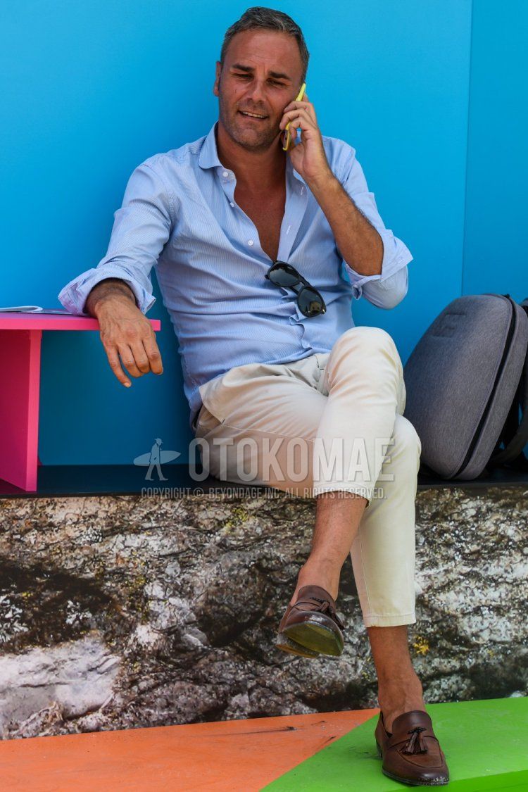 Men's spring/summer coordinate and outfit with plain light blue shirt, plain beige chinos, and brown tassel loafer leather shoes.