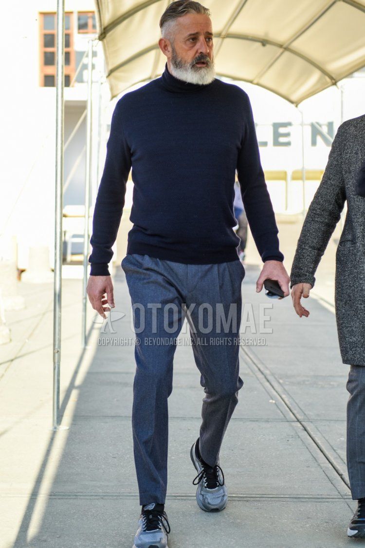 Spring and fall men's coordinate and outfit with plain navy turtleneck knit, plain gray slacks, plain gray pleated pants, and gray low-cut sneakers.