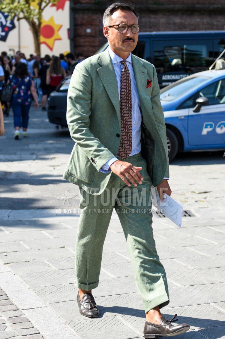 Men's spring, summer, and fall coordination and outfit with plain black glasses, light blue striped shirt, brown tassel loafer leather shoes, and multi-colored plain tie.