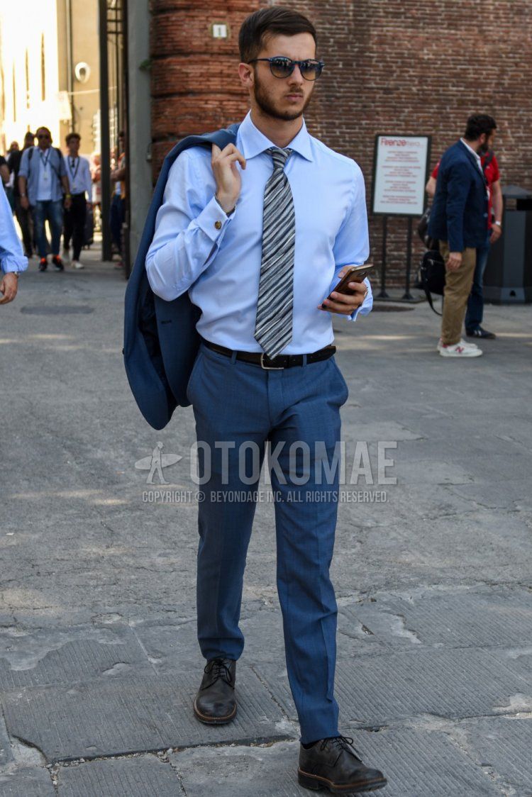 Men's spring/summer/fall outfit with plain black sunglasses, plain light blue shirt, plain black leather belt, plain gray slacks, plain black toe leather shoes, and plain brown/white tie.