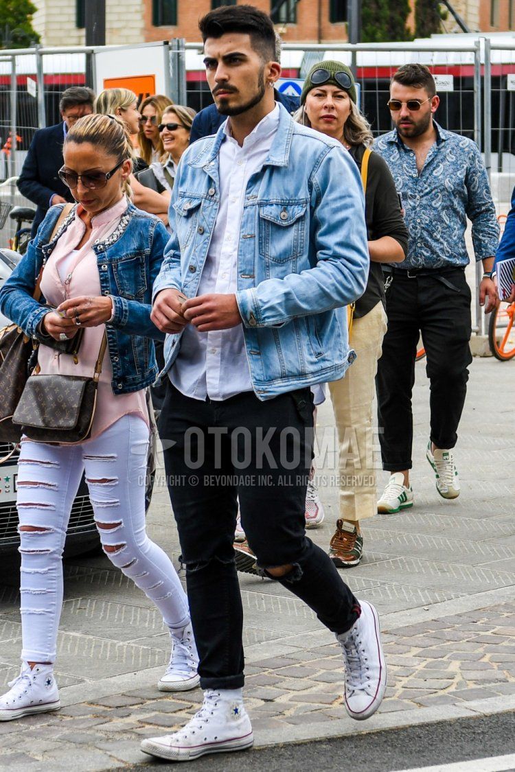 Men's spring, summer, and fall coordinate and outfit with plain light blue denim jacket, plain white shirt, plain black damaged jeans, and white high-cut Converse sneakers.