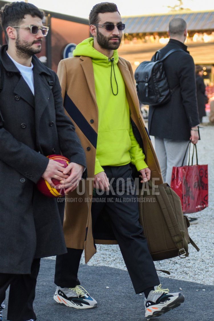 Silver solid sunglasses, solid beige chester coat, solid yellow hoodie, solid gray slacks, solid gray ankle pants, solid black socks, Adidas Easy Boost gray low cut sneakers, solid beige backpack for fall and winter. Men's Codes and Outfits.