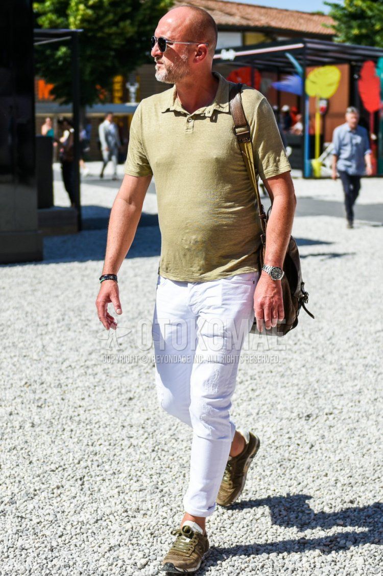 Men's spring/summer coordinate and outfit with plain black/silver sunglasses, plain beige polo shirt, plain white damaged jeans, and Premiata olive green low-cut sneakers.