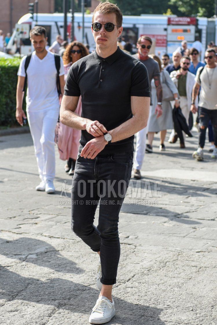 Summer men's coordinate/outfit with plain black sunglasses, plain black polo shirt, dark gray plain denim/jeans, and white low-cut sneakers.