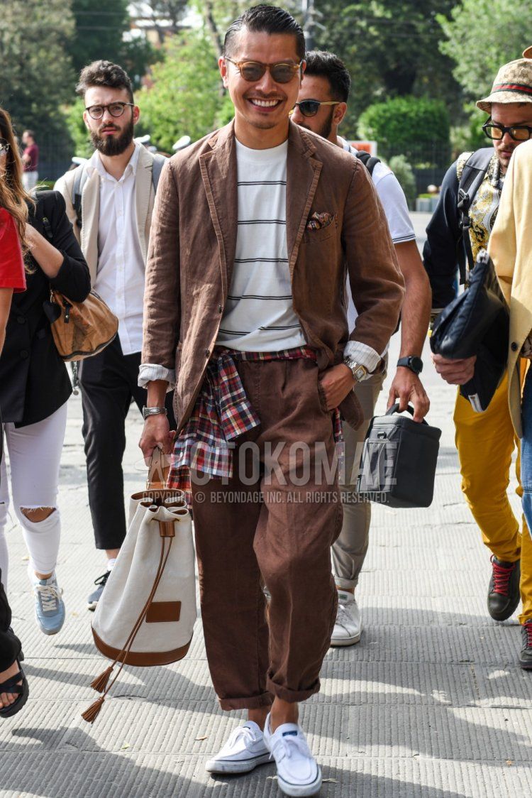 Men's spring, summer, and fall coordination and outfit with plain brown sunglasses from Boston, white striped t-shirt, white low-cut sneakers, plain white bag, and plain brown suit.