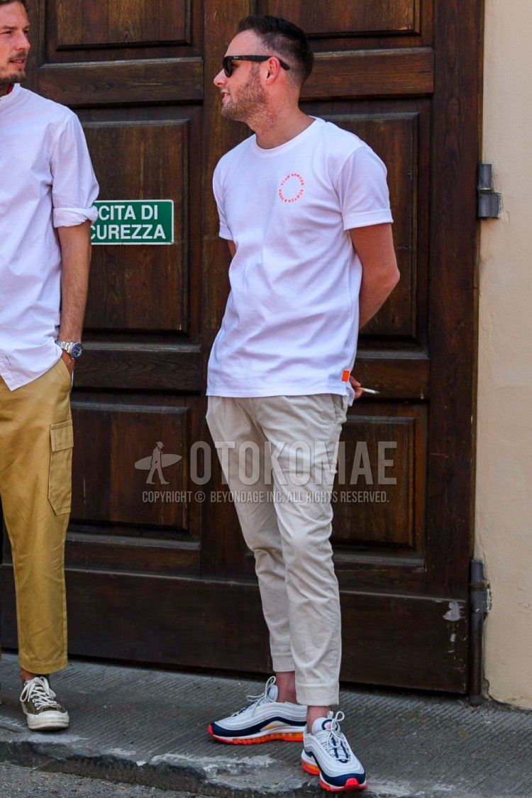 Men's summer coordinate and outfit with plain white t-shirt, plain beige cotton pants, and Nike Air Max 97 white low-cut sneakers.