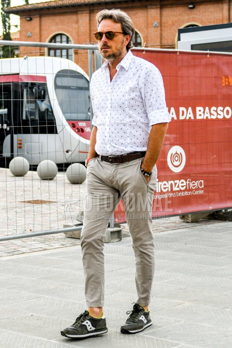 Men's summer coordinate and outfit with plain sunglasses, white top/inner shirt, plain brown leather belt, plain beige chinos, solid beige ankle pants, and olive green low-cut sneakers from Succaney.