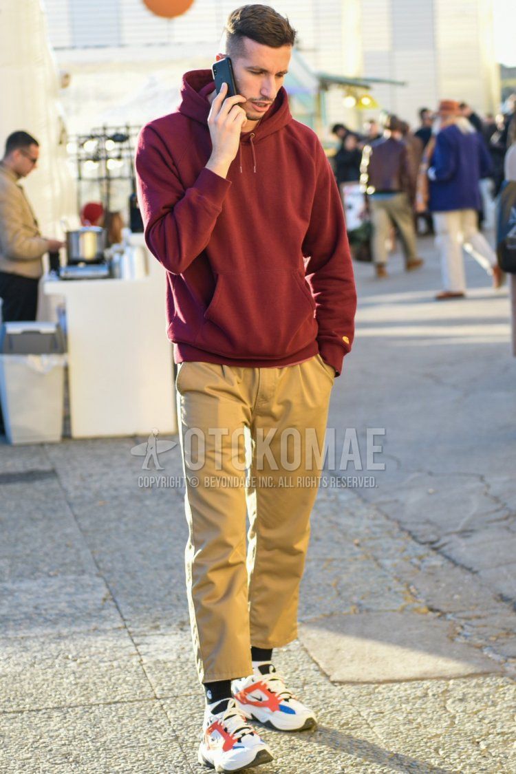 Spring and fall men's coordinate and outfit with Carhartt red solid color hoodie, beige solid color chinos, beige solid color cropped pants, Carhartt black one-point socks, and Nike m2k techno multi-color low-cut sneakers.