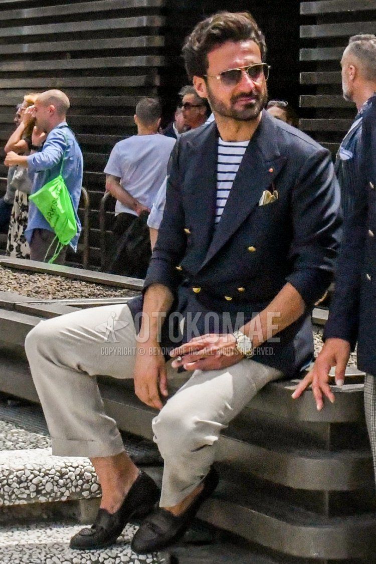 Men's spring, summer, and fall coordinate and outfit with plain sunglasses, plain navy tailored jacket, white striped t-shirt, plain beige chinos, and black coin loafer leather shoes.