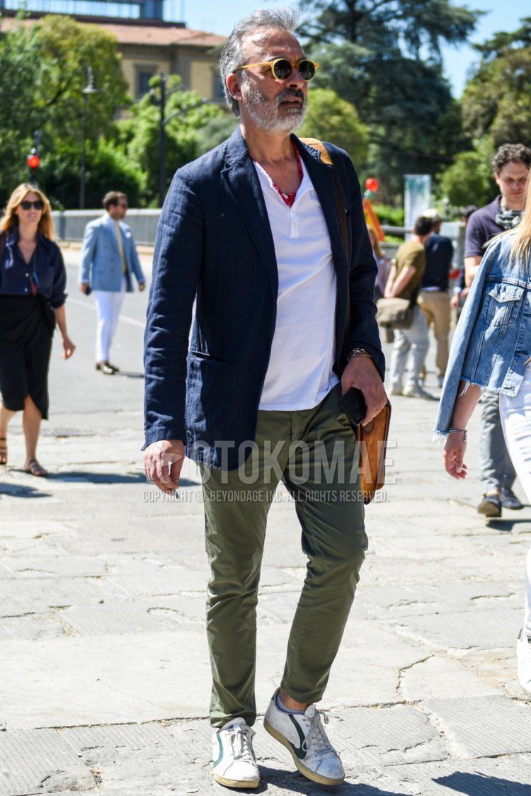 Spring and fall men's coordinate and outfit with plain beige sunglasses, red stole bandana/neckerchief, plain navy linen tailored jacket, plain white t-shirt with henley neck, plain olive green chinos, and white low-cut sneakers.