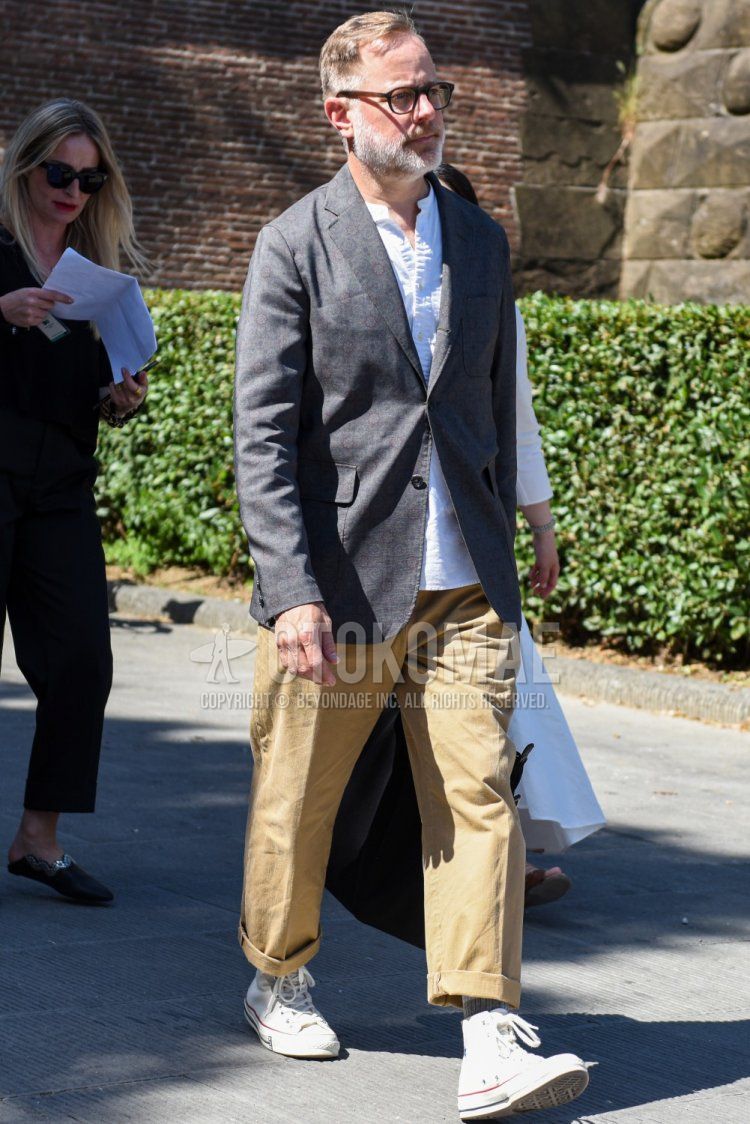 Men's spring, summer, and fall coordinate and outfit with plain black/brown glasses, plain gray tailored jacket, collarless plain white shirt, plain beige wide pants, plain gray socks, and white high-cut Converse sneakers.
