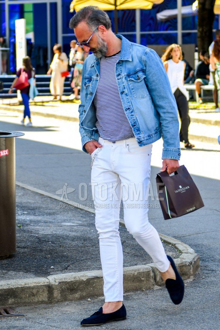 Men's spring/autumn coordinate and outfit with plain blue sunglasses, plain blue denim jacket, white/navy striped t-shirt, plain white denim/jeans, and suede navy tassel loafer leather shoes.
