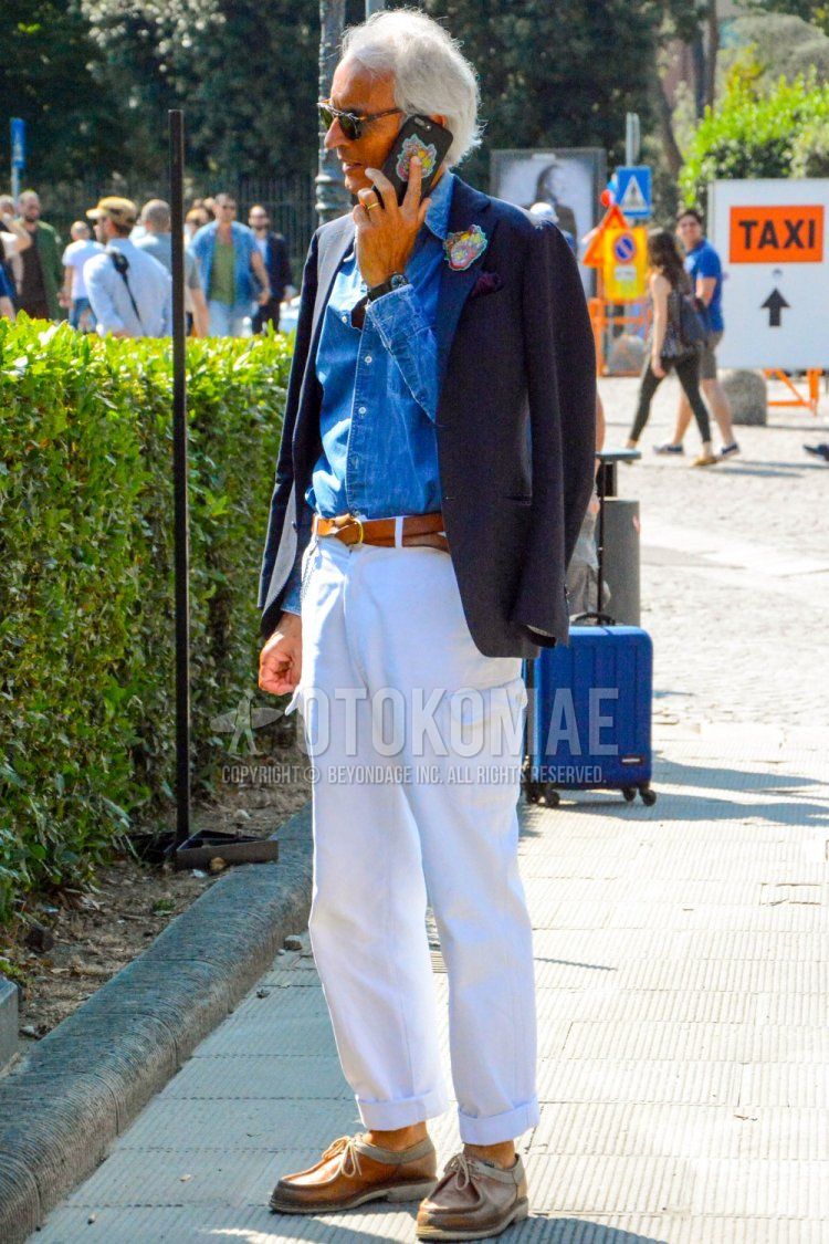 Men's spring/summer/autumn coordinate and outfit with brown tortoiseshell sunglasses, plain navy tailored jacket, plain blue denim/chambray shirt, plain brown leather belt, plain white cotton pants, plain white cargo pants, brown moccasins/deck shoes leather shoes.