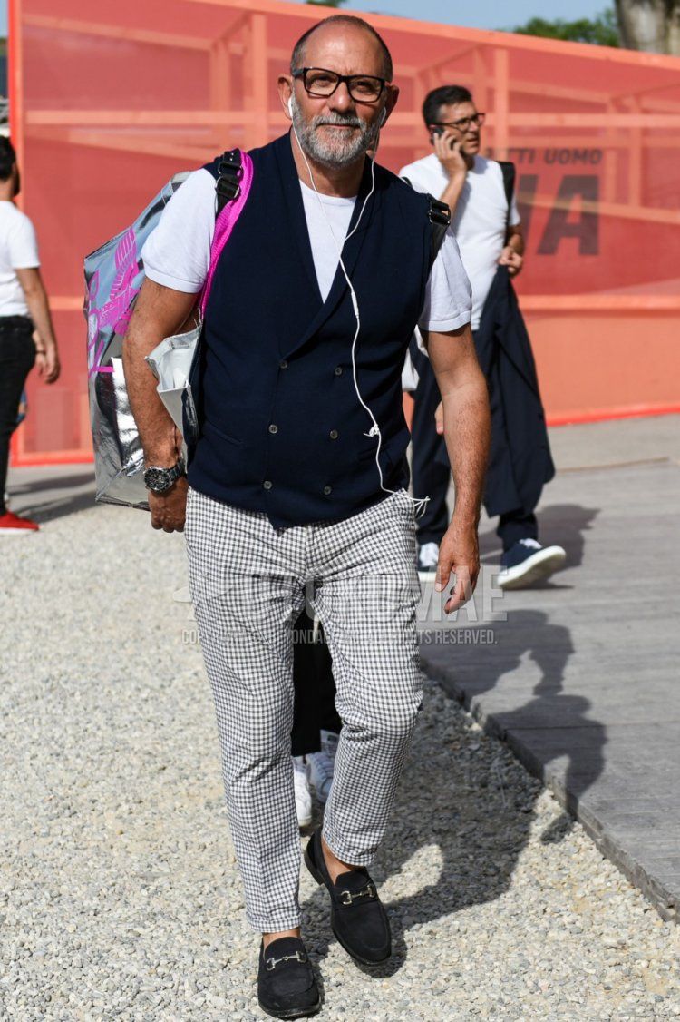 Men's summer coordinate and outfit with plain glasses, plain navy gilet, plain white t-shirt, white/black checked slacks, and suede black bit loafer leather shoes.