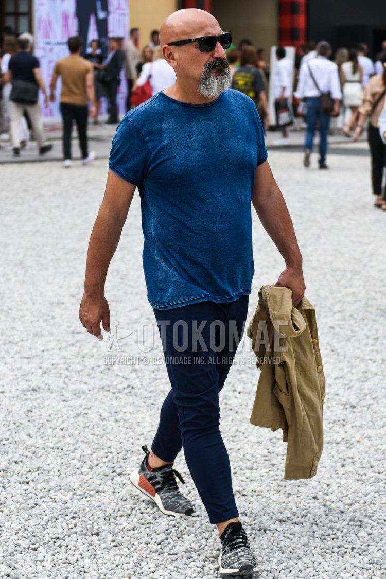 Men's summer coordinate and outfit with Ray-Ban plain black sunglasses, plain blue t-shirt, plain navy chinos, and Adidas NMD gray low-cut sneakers.