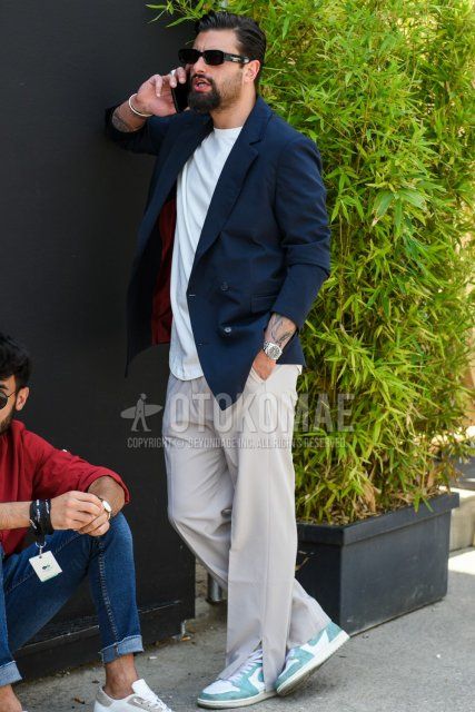 Men's spring and summer coordinate and outfit with plain black sunglasses, plain navy tailored jacket, plain black t-shirt, plain beige slacks, and Nike Air Jordan 1 Turbo Green light blue and white high-cut sneakers.