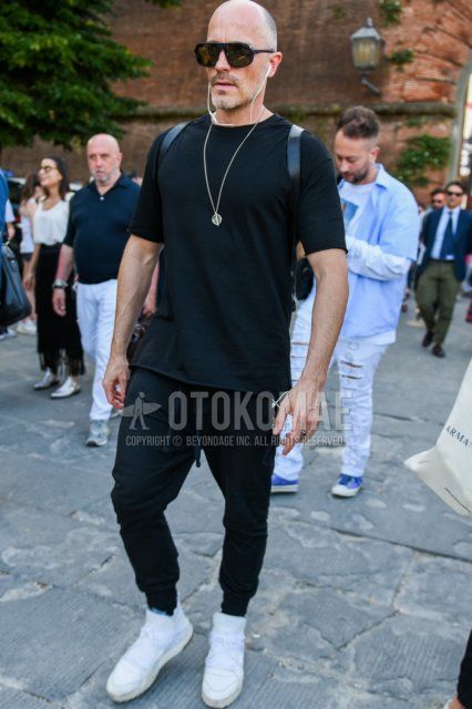 Men's summer coordinate and outfit with plain black sunglasses, plain black t-shirt, plain black easy pants, plain jogger pants/ribbed pants, and white high-cut sneakers.