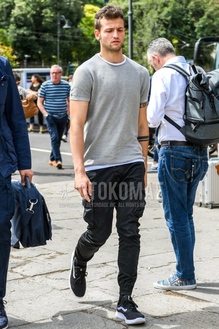 Men's summer coordinate and outfit with plain gray sweater, plain white t-shirt, plain black cargo pants, plain black jogger pants/ribbed pants, plain black socks, and black low-cut sneakers by Vans.