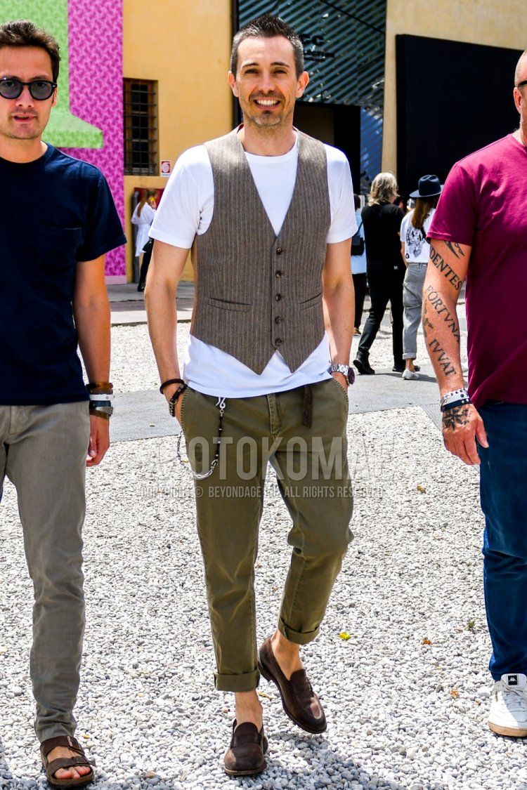 Summer men's coordinate and outfit with beige striped gilet, plain t-shirt, plain green chinos and brown coin loafer leather shoes.