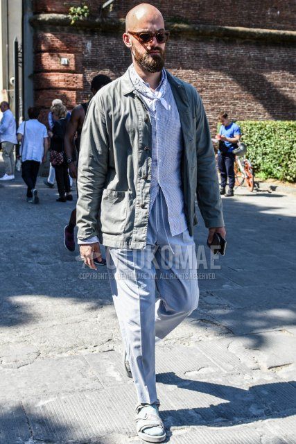 Men's spring, summer, and fall coordinate and outfit with brown tortoiseshell sunglasses, white paisley bandana/neckerchief, plain gray coach jacket, white striped shirt, plain gray easy pants, and gray sport sandals.