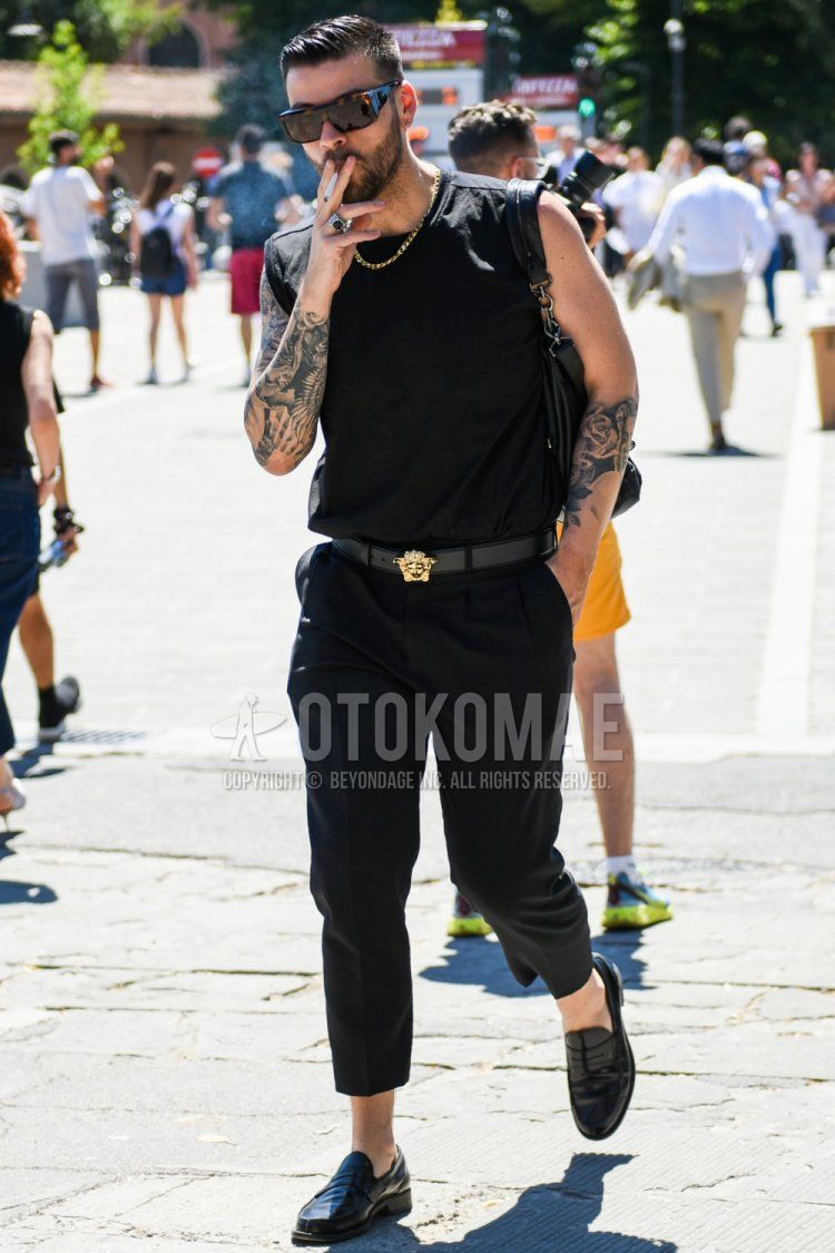 Men's summer coordinate and outfit with brown tortoiseshell sunglasses, plain black tank top, plain black leather belt, plain black slacks, plain cropped pants, black coin loafer leather shoes, and plain black shoulder bag.