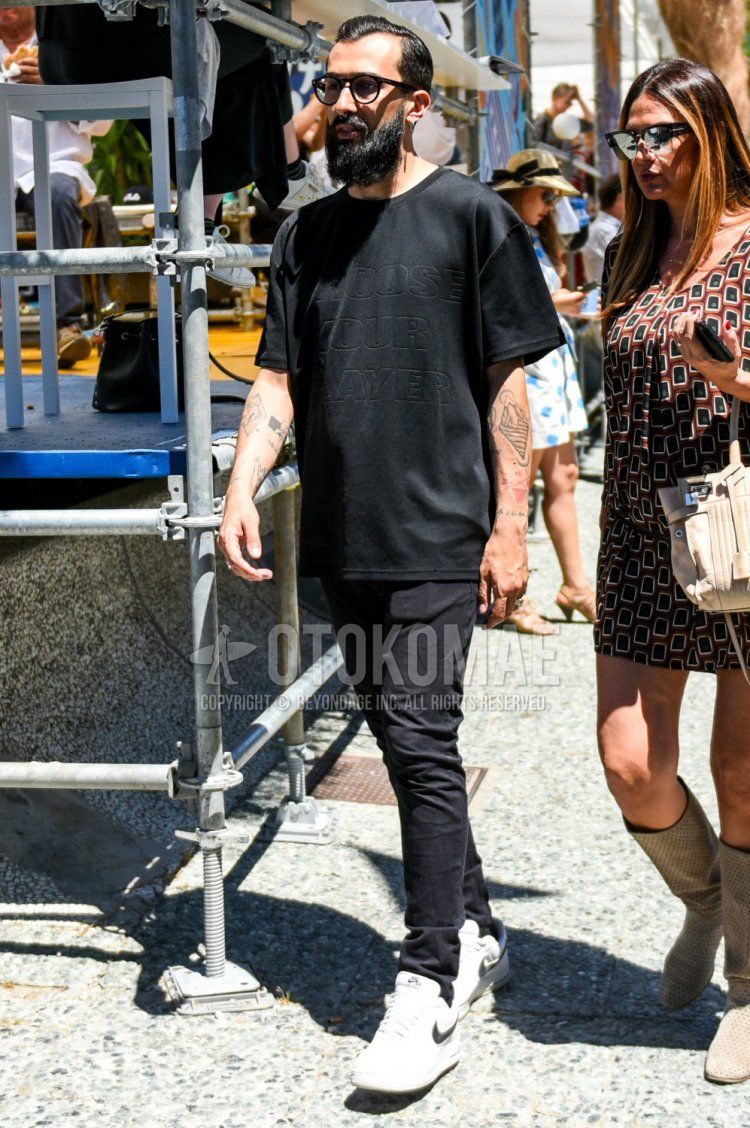 Men's summer coordinate and outfit with plain black glasses, plain black t-shirt, plain black cotton pants, and Nike white low-cut sneakers.
