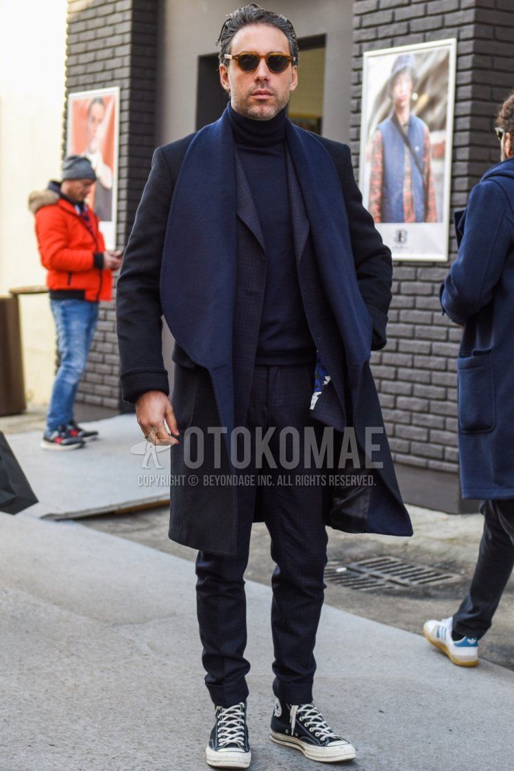 Men's fall/winter outfit and outfit with brown tortoiseshell sunglasses, dark gray solid outerwear, dark gray solid turtleneck knit, black high-cut Converse All Star sneakers, and dark gray check suit.