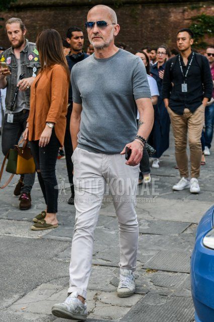 Men's summer coordinate and outfit with plain silver sunglasses, plain gray t-shirt, plain white cotton pants, and white low-cut Adidas sneakers.
