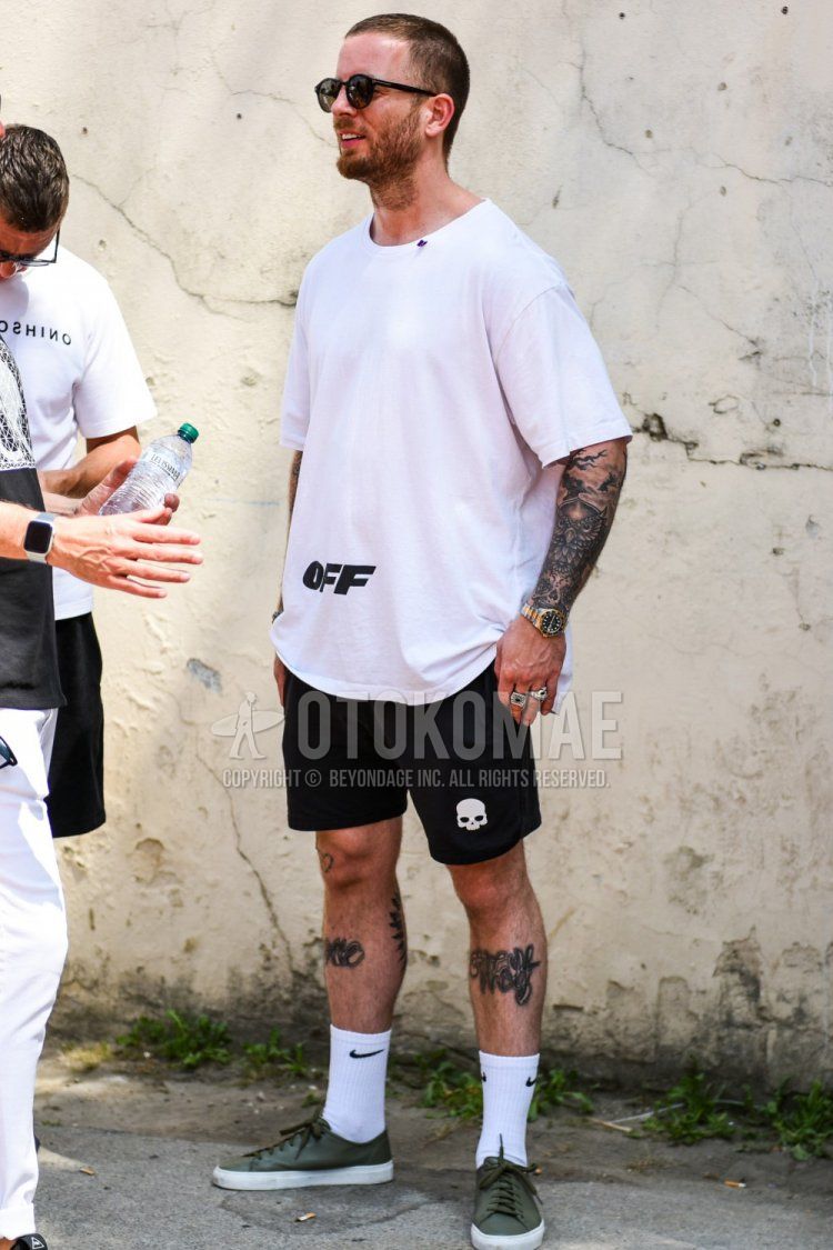 Summer men's coordinate and outfit with Tom Ford plain black sunglasses, off-white plain white t-shirt, plain black shorts, Nike one-point white socks, and olive green low-cut sneakers.