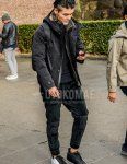Men's fall/winter outfit with plain black mountain parka, plain black t-shirt, plain black easy pants, plain black jogger pants/ribbed pants, and Nike Air Force One white/black low-cut sneakers.