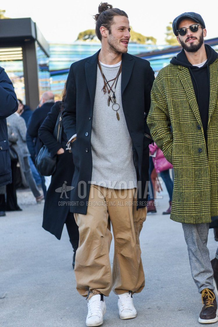 Men's fall/winter coordinate and outfit with dark gray solid color chester coat, gray solid color sweater, beige solid color chinos and white low-cut sneakers.