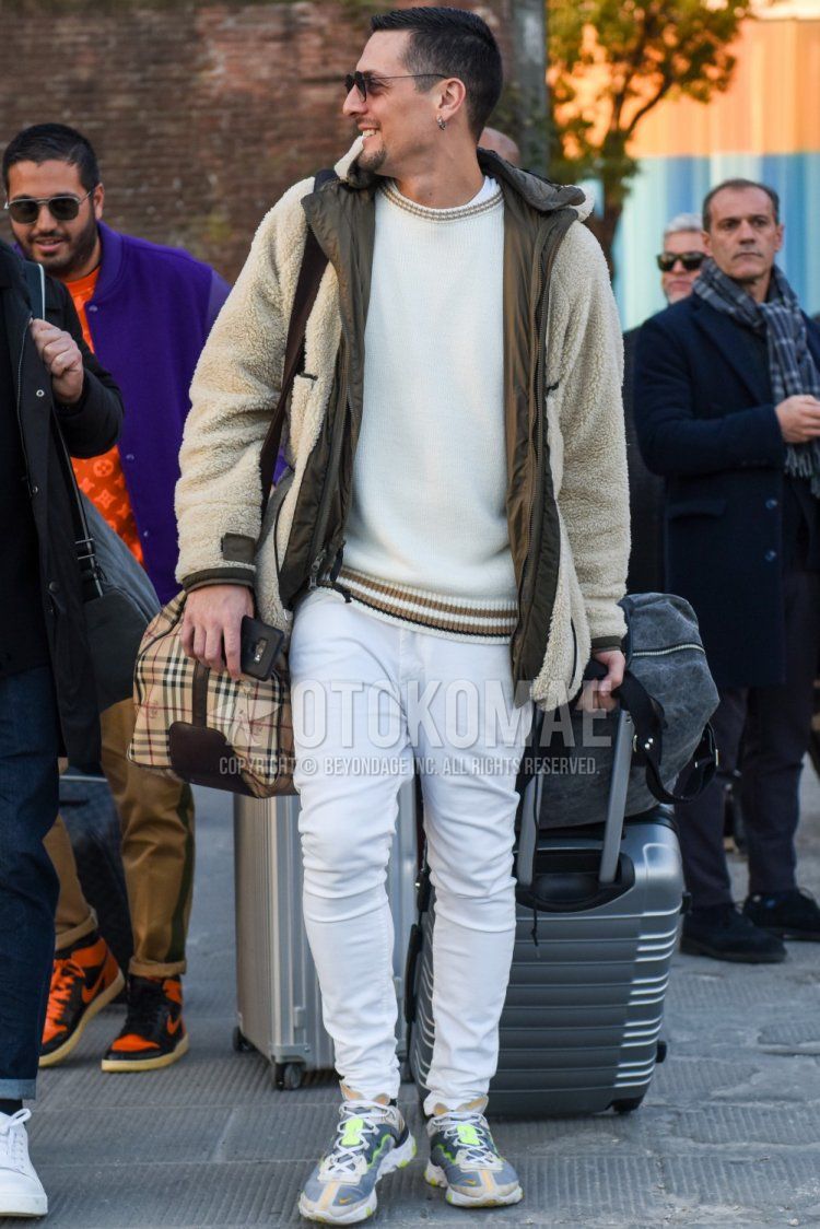 Men's fall/winter outfit with solid black sunglasses, solid white fleece jacket, solid olive green inner down, solid white sweater, solid white cotton pants, Nike React Element 87 clear low-cut sneakers, Burberry solid beige Boston bag Outfit.