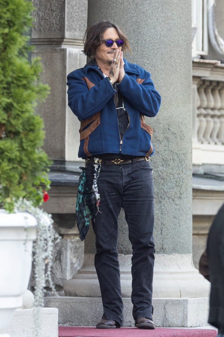 Actor Johnny Depp gestures to the fans before meeting with Serbian President Aleksandar Vucic in front of his office in Belgrade